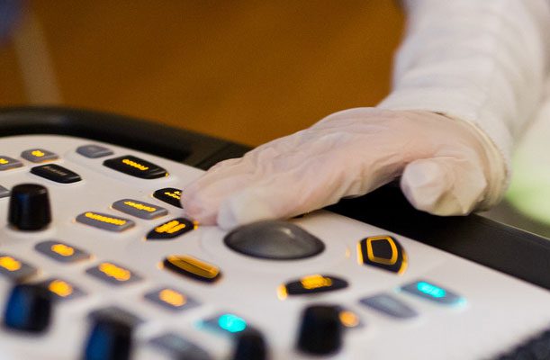 A healthcare worker operates diagnostic machinery . 