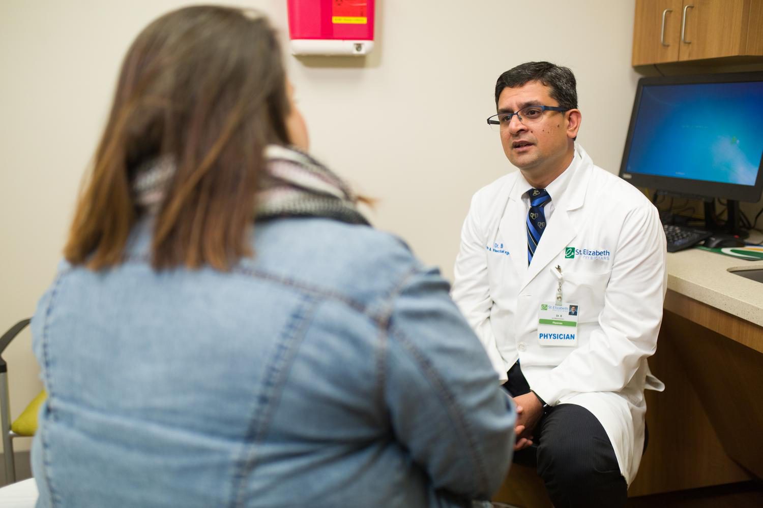 Dr. Bikhchandani speaks with patient in medical office. 